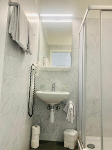贝林佐拉甘珀酒店的白色的浴室设有水槽和淋浴。