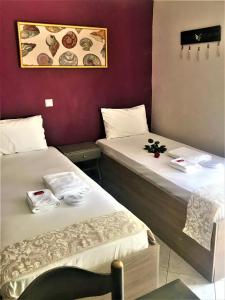 利迈纳里亚Grecian Sea的紫色墙壁客房的两张床