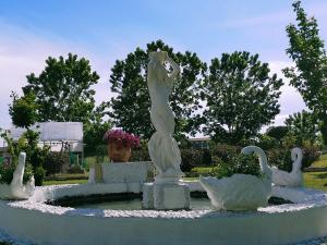 格罗塞托港伊莎贝拉别墅酒店的一座喷泉,上面有女人和天鹅的雕像