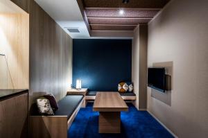 京都Homm Stay Nagi Shijo Kyoto By Banyan Group的客房设有长凳、桌子和电视。