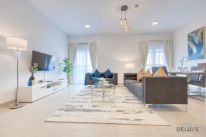 迪拜Splendid 2BR in Victoria Residency Al Furjan by Deluxe Holiday Homes的客厅配有沙发和桌子