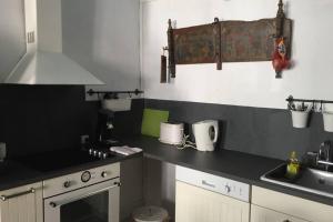 奥泽兰河畔弗拉维尼La petite maison médiévale de Melanie的厨房配有黑色台面和水槽