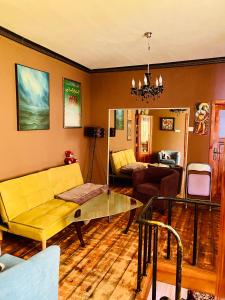 布尔加斯Бургасский дом的客厅设有黄色沙发和玻璃桌