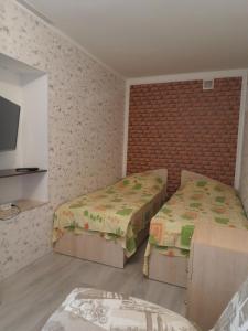 雅尔塔Guest House Mango的一间卧室设有两张床,墙上配有电视。