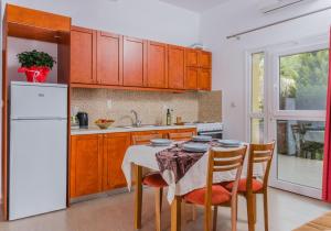 卡拉马基Arsinoi Studios and Apartments的厨房配有桌子和白色冰箱。