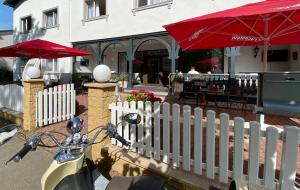 巴贝Hotel Altes Kurhaus的停在白色围栏和餐厅旁边的摩托车