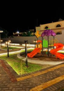Al Qarāḩīnبيات للنزل السياحية的一个带滑梯和遮阳伞的游乐场