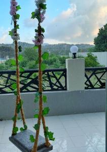 Al Qarāḩīnبيات للنزل السياحية的阳台上种着两朵人工花
