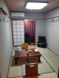 京都OHTO Ryokan的一间带桌子的客厅和一间带椅子的房间