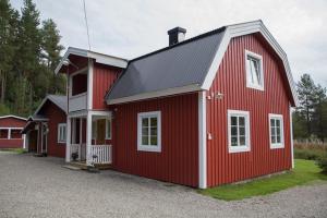 ÅsarneKolbacken stugby & Camping的一座红色谷仓,房子上装饰着白色的饰物