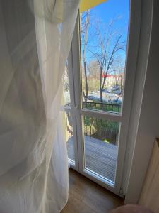 布加勒斯特Cozy apartment in the Business area of Bucharest的窗户配有窗帘,享有庭院的景色