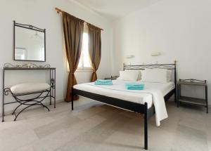 纳克索乔拉Ammosis Inn的一间卧室配有一张床、一把椅子和镜子