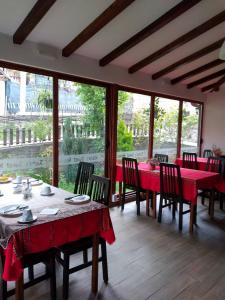 奥赫里德里斯托宾馆的一间设有红色桌椅和窗户的用餐室