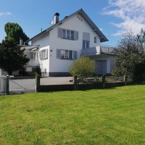 卢斯特瑙Ferienhaus Hämmerle´s的白色的房子,有栅栏和院子