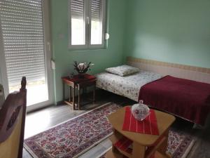Surčin飞机T&T公寓的一间卧室配有一张床、一张桌子和一个窗户。