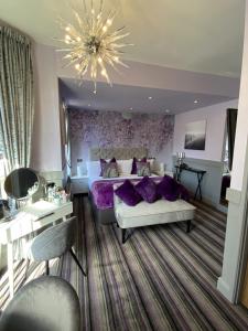 布莱克浦罗斯金酒店的一间卧室配有一张带紫色枕头的大床