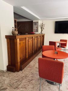 纳夫普利翁纳夫普利亚酒店的一间设有桌椅和电视的等候室