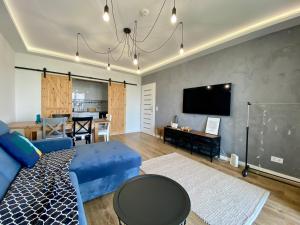 卢布林SunRise Apartament的客厅配有蓝色的沙发和电视