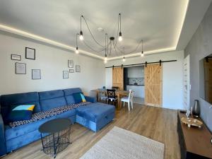 卢布林SunRise Apartament的一间带蓝色沙发的客厅和一间用餐室