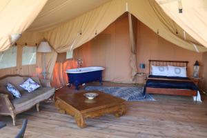 马尔赛Les Toiles de La Tortillère tentes luxes safari lodge glamping insolite的一间帐篷内带一张床和一个浴缸的房间