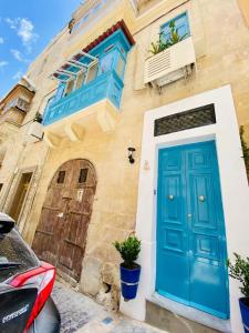 瓦莱塔Maltese town house的一栋带房子的建筑上的一扇蓝色门