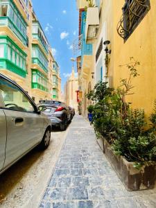 瓦莱塔Maltese town house的一条街道,汽车停在大楼的一侧