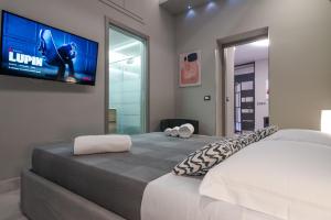 卡塔尼亚Suite Catania Lungomare的卧室配有一张壁挂式平面电视的床。