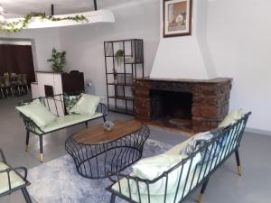LobatseDRIFTWOOD BOUTIQUE BED AND BREAKFAST的客厅设有壁炉、椅子和桌子