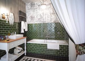 柏林高基公寓酒店的浴室铺有绿色地铁瓷砖,配有浴缸和水槽