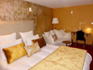 Lusignan乐查普罗格酒店的酒店客房配有白色的床和沙发。