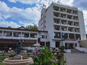 萨拉他蒙蒂鲁Hotel Spa Cazino Monteoru的前面有雕像的建筑