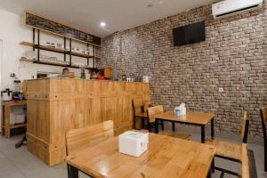 SunggalSeindo Hotel Mitra RedDoorz的餐厅设有木桌和砖墙