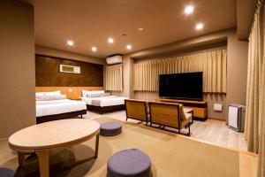 京都Randor Residential Hotel Kyoto Suites的酒店客房设有一个带电视的起居区。
