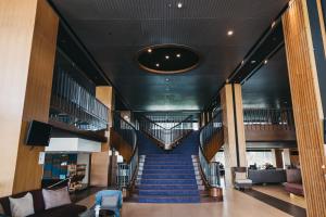 董里Rua Rasada Hotel - The Ideal Venue for Meetings & Events的蓝色地毯的建筑中的螺旋楼梯