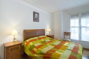 萨莫拉Merlú Apartamento con garaje的一间卧室配有一张带五颜六色棉被的床