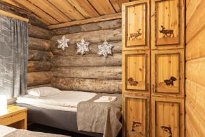 萨利色尔卡极光小屋度假屋的小木屋内一间卧室,配有一张床