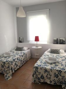 伊斯兰蒂拉Hacienda Golf Ático Islantilla的一间卧室设有两张床和窗户。