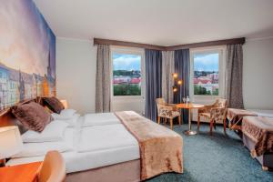 布拉格Plaza Prague Hotel - Czech Leading Hotels的酒店客房带一张床、一张桌子和椅子