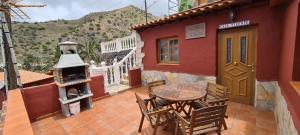 巴列埃尔莫索Casa Rural Vicente的一个带桌子和燃木炉的庭院
