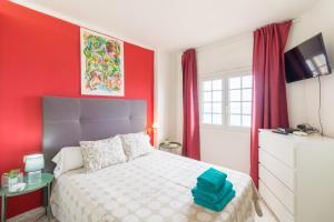 皮内达德马尔Apartment in front of the Beach的一间卧室配有一张红色墙壁的床