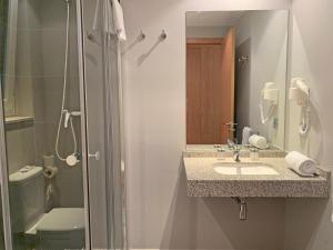 阿林萨尔Apartamentos Vallnord 3000的一间带水槽、淋浴和卫生间的浴室