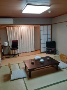 京都OHTO Ryokan的客厅配有桌子和两把椅子