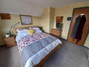 哈文特Comfort House的一间卧室配有一张大床,铺有红色和灰色的毯子