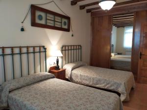 SobradilloCasa de turismo rural - Mirador de Santa Marina的一间卧室配有两张床和镜子