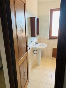 萨穆盖奥Agriturismo da Lino AGRIPIZZA的一间带水槽、卫生间和门的浴室