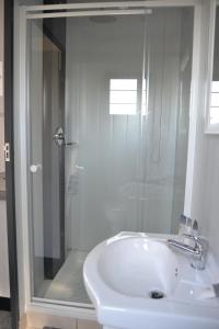 白河SleepOver KMIA的带淋浴和白色盥洗盆的浴室
