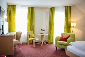 莱因斯韦勒山庄酒店及餐厅的酒店客房带一张床、一张桌子和椅子
