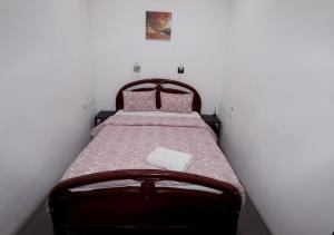 里斯本迎宾旅馆的一间小卧室,配有一张带粉红色床单的床