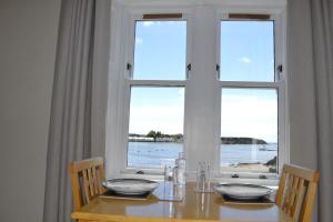 埃伦港Eilidh’s Guest House的桌椅和海景窗户。