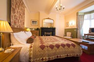 卡纳芬Victoria House Room Only Accommodation的一间卧室配有一张床、一张桌子和一个壁炉